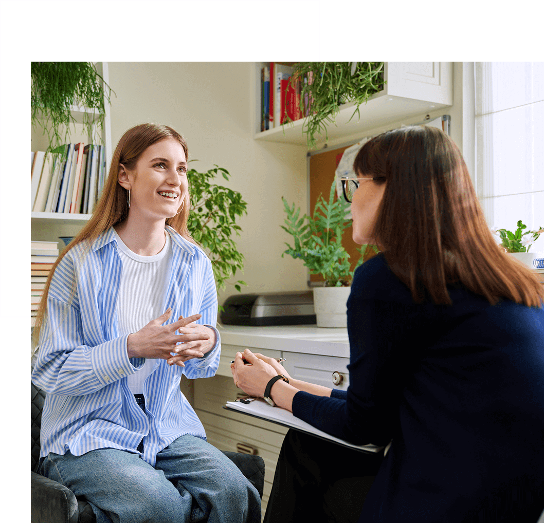 Two women engaged in a friendly conversation indoors.